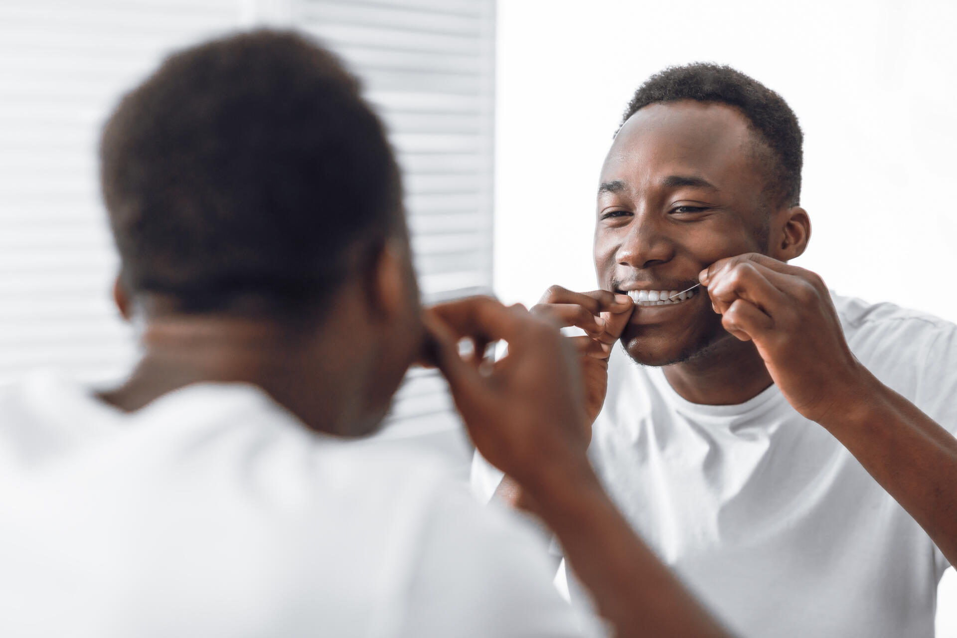 man-flossing-to-reduce-cavities-and-gingivitis