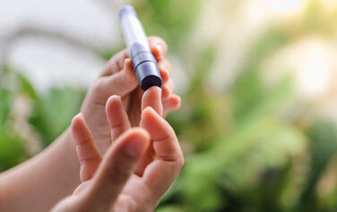closeup image of a person performing a fingerstick test on themselves
