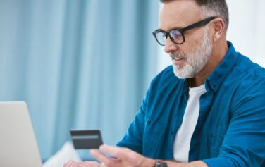 A middle-aged man is shown purchasing a CGM with his FSA card online.